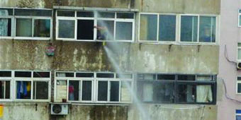 Fire Fighters Use Water Cannon to Blast Suicidal Man through Window